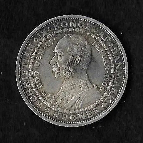 A round silver Danish crown coin featuring a profile portrait of King Christian IX, photographed against a dark textured background.