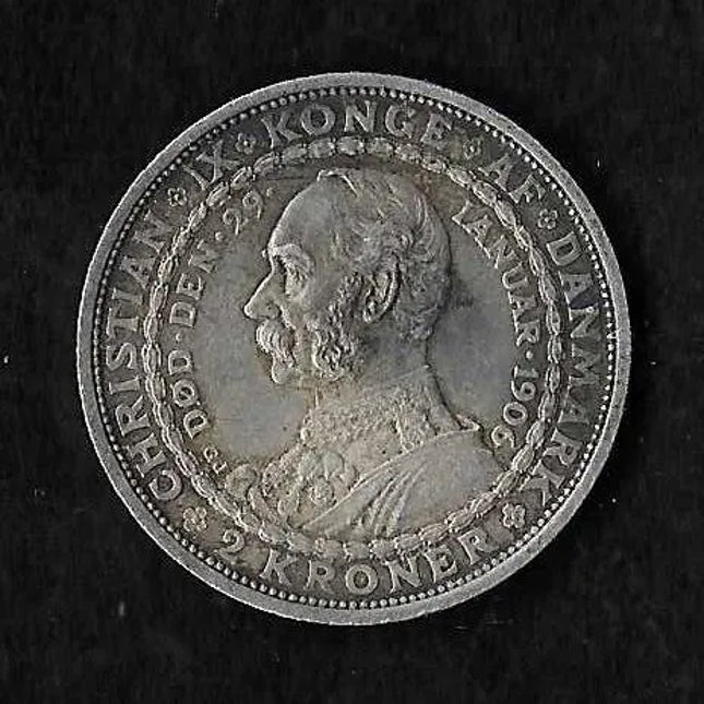 A round silver Danish crown coin featuring a profile portrait of King Christian IX, photographed against a dark textured background.
