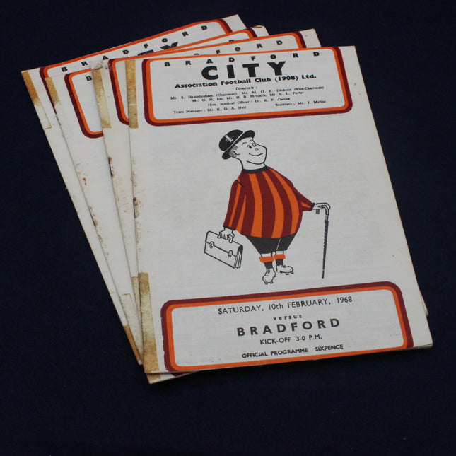 Stack of Bradford City Association Football Club programmes on a dark background
