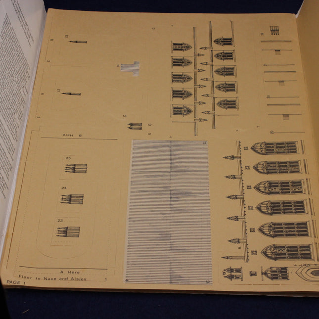 Open book with architectural drawings on a dark surface