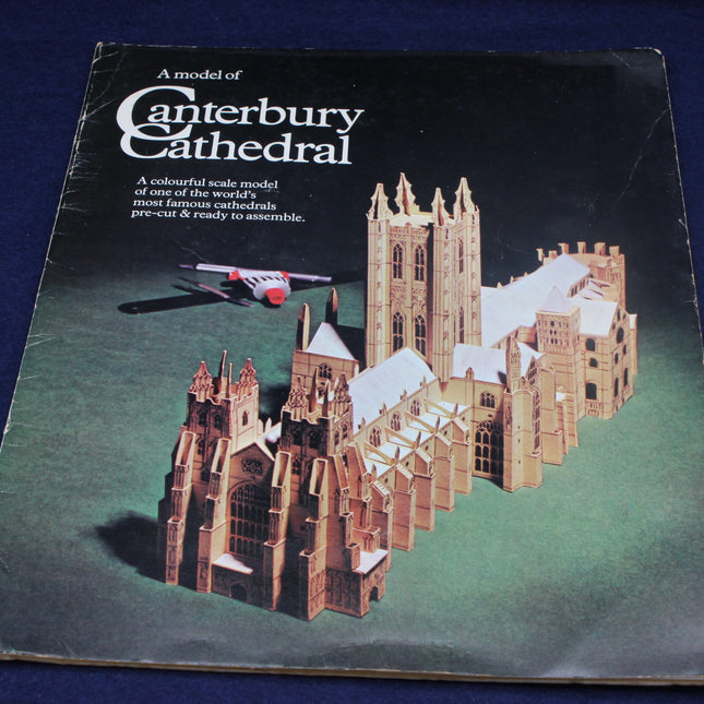 Model of Canterbury Cathedral packaging with cathedral model and airplane on a blue background