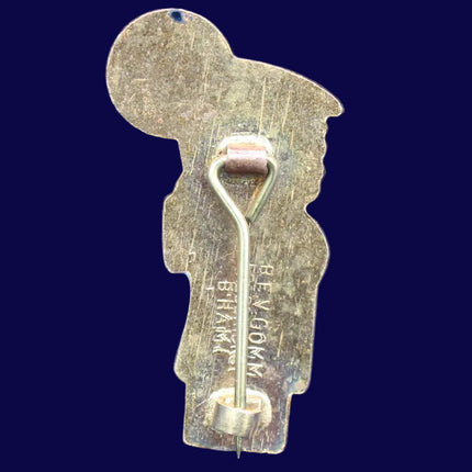 Metal Golly Badge with 'REV COMM' engraving on a dark blue background