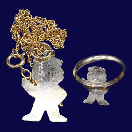 Gold necklace with a pendant and a matching ring on a blue background