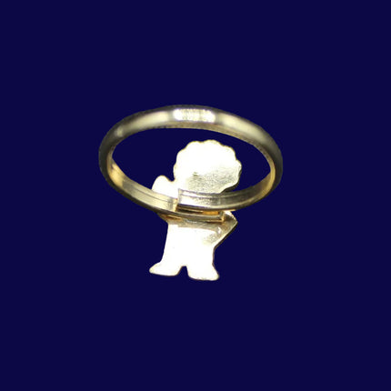 Gold Golly ring with a small angel figure on a dark blue fabric background