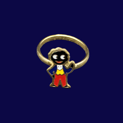 Small ring with a Golly character charm on a blue fabric background
