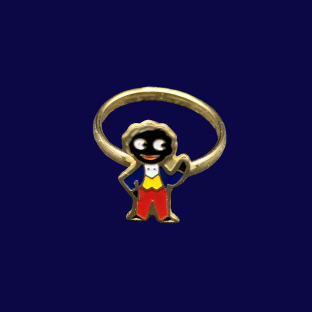 Small ring with a Golly character charm on a blue fabric background