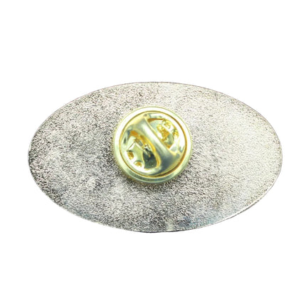 Metallic oval badge with a central emblem on a blue textured background