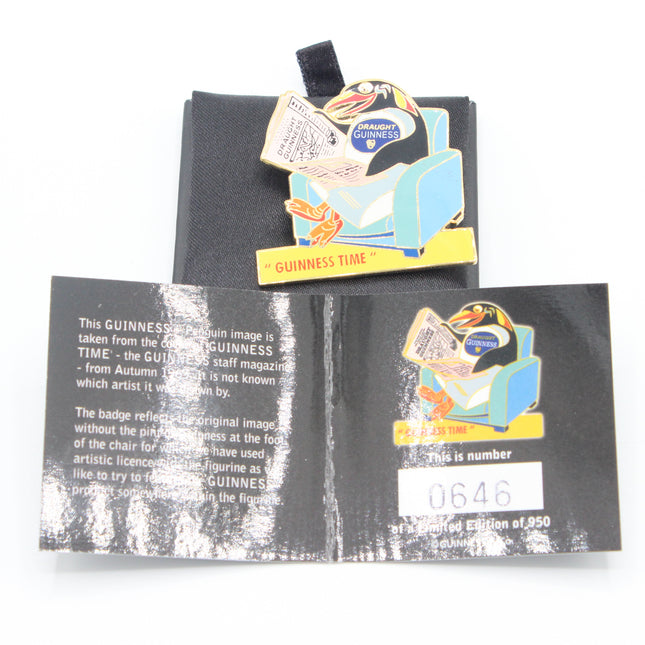 A Guinness-themed enamel pin displayed on top of its black backing card, with an additional back card or insert below showing printed details and a white price sticker. The pin depicts a penguin sitting in a blue armchair with a newspaper and the words 'Guinness' and 'Guinness Time'.
