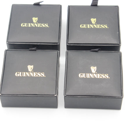 Four black Guinness gift boxes arranged in a 2x2 grid on a white background, each printed with the gold Guinness logo and name.