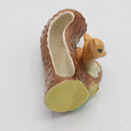 A ceramic squirrel-shaped dish or planter shaped like a tree trunk cut with a hollow center, featuring a small brown and cream squirrel figurine on the side, photographed on a plain white background.
