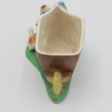 A vintage ceramic mushroom-shaped planter with two small dog figurines, shown on a plain white background.
