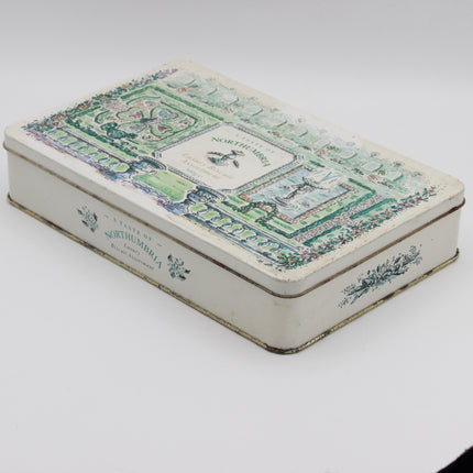 A vintage rectangular metal tin box with a cream-colored base and an ornate green and blue architectural illustration on the lid, featuring the text 'NORTHUMBERLAND' and 'Bath and Northumberland'.