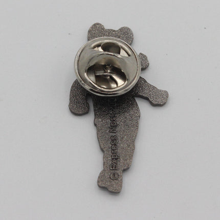 The back view of a small bear-shaped metal pin, showing a textured silver-gray body and a shiny circular pin clasp on a plain light gray background.