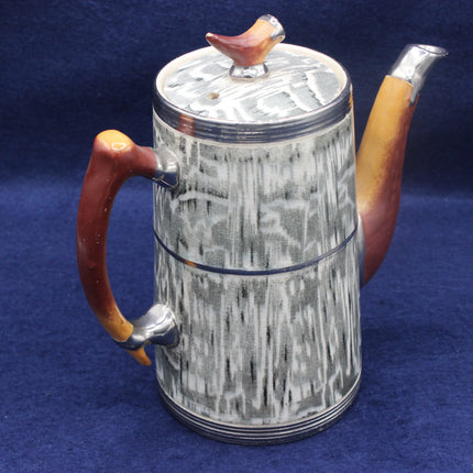 Teapot with wooden handle and bird-shaped knob on a blue background