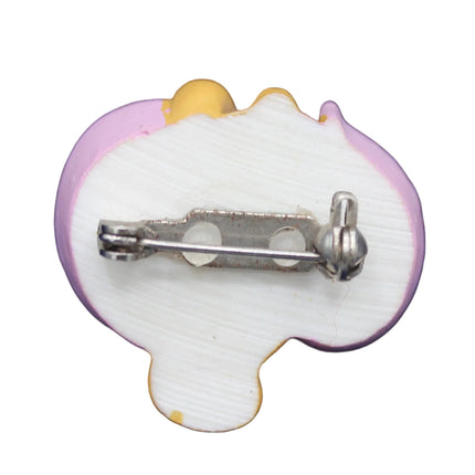 Small decorative pin with a heart shape on a white background