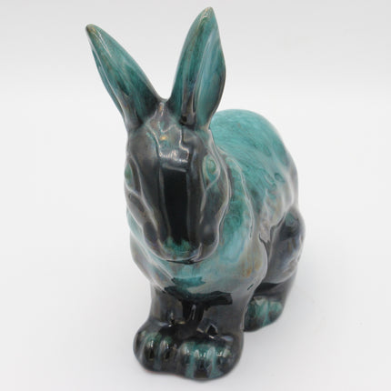 A ceramic rabbit figurine with a glossy glaze featuring a mottled teal, turquoise, and black color combination, set against a plain white background.