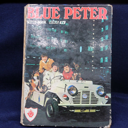 Vintage 'Blue Peter' book with cover illustration of children and a vehicle, on a dark background.
