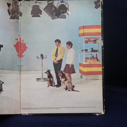 Album cover with two people and dogs in a studio setting
