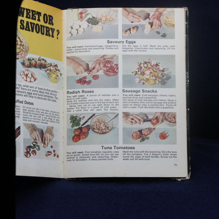 Open book with food preparation instructions and illustrations on a dark background