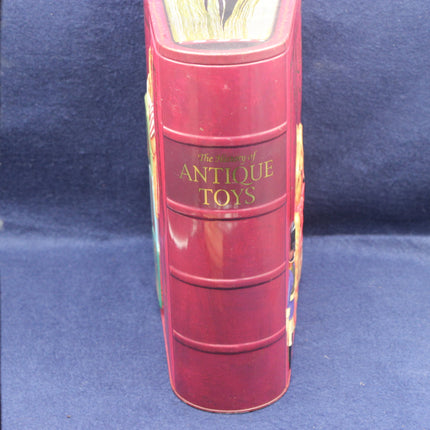 Red cylindrical book-shaped container with 'The Treasury of Antique Toys' text on a blue background
