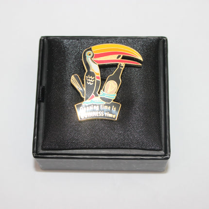 Toucan-shaped pin with a humorous message on a black box