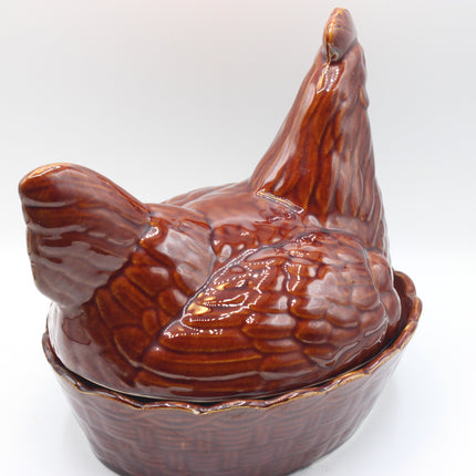 A glossy brown ceramic lidded container shaped like a chicken, photographed against a plain light background.