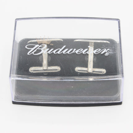 A pair of silver-toned metal cufflinks displayed inside a clear plastic presentation box with a black insert. The insert features the Budweiser script logo in white.