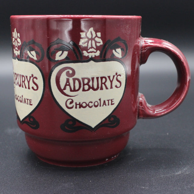 Red mug with Cadbury's Chocolate logo on a dark background