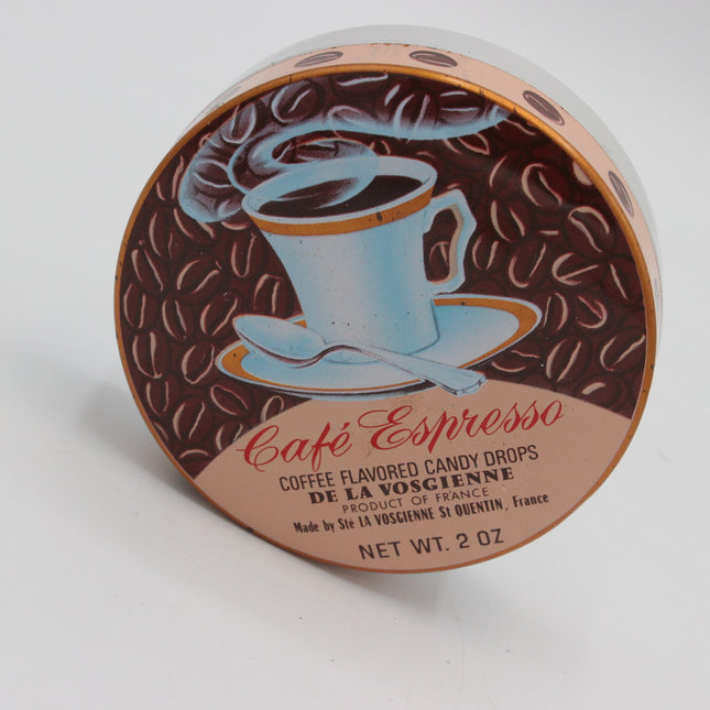 A round tin of Café Espresso coffee flavored candy drops by De La Vosgienne, featuring a brown coffee bean pattern and an illustration of a light blue coffee cup on a saucer.