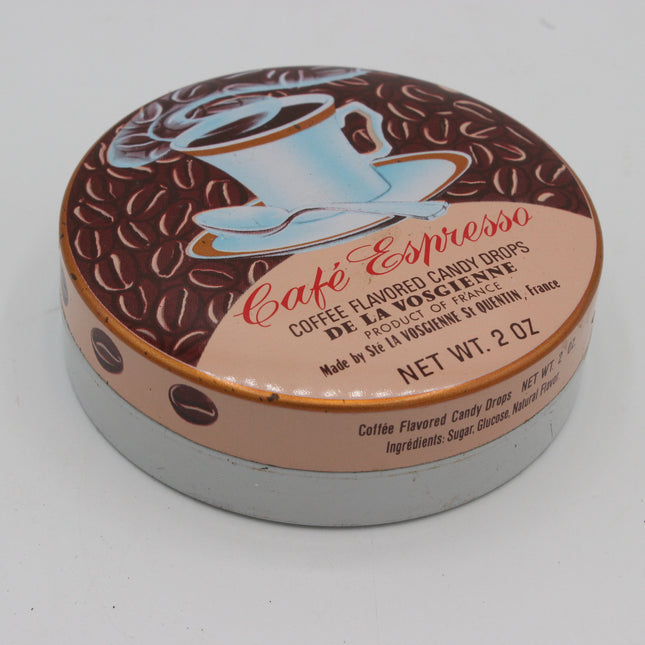 A round tin of Dela Vosciense Café Espresso coffee flavored candy drops, featuring a brown coffee bean pattern lid with a light blue coffee cup illustration and a peach-colored label.