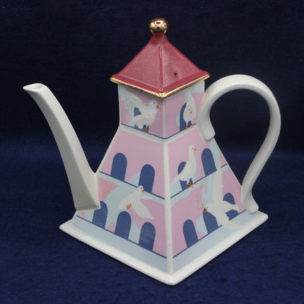 Decorative teapot with a lbird design on a dark blue background