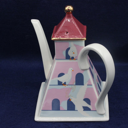Decorative teapot with a white dove bird design on a dark blue background