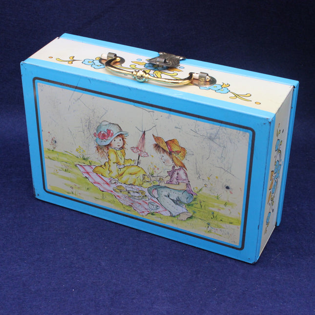 Blue childs sweet box with illustrations of two children on a grassy field
