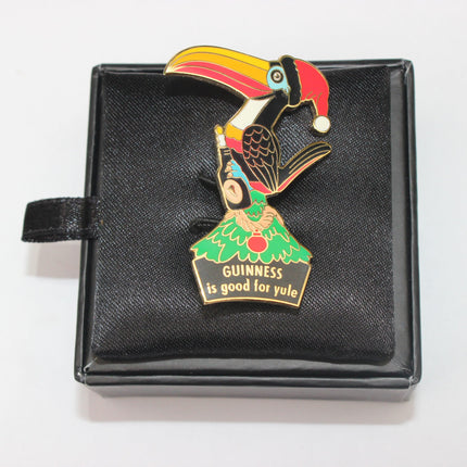 Colorful toucan pin with 'Guinness is good for yule' text on a black box
