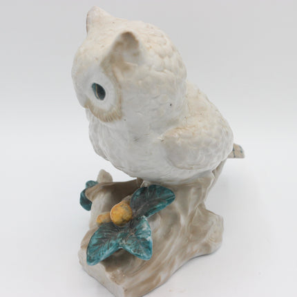 A vintage ceramic owl figurine perched on a branch with teal and yellow accents, photographed against a plain white background.