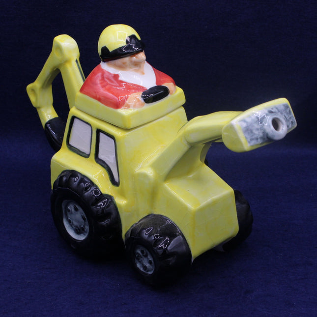 Yellow toy bulldozer with a Santa Claus figure on a dark blue background