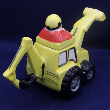 Yellow toy bulldozer with a red top on a dark blue background