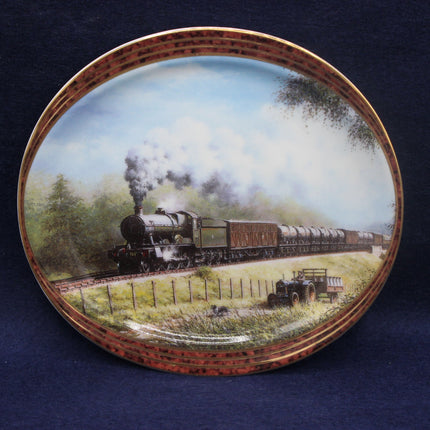 Decorative plate with a painting of a steam train on a blue background