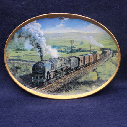 Decorative plate with a steam train on a landscape design against a blue background