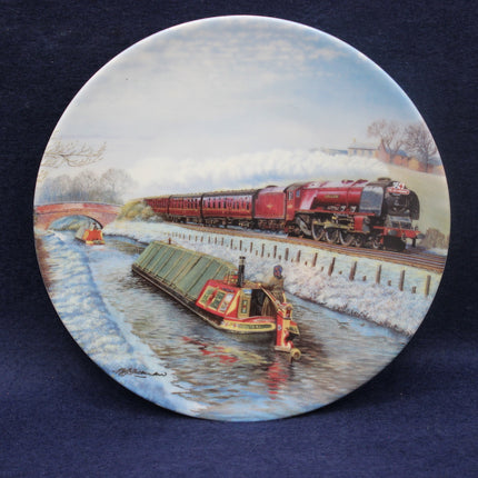 Decorative plate with a steam train and boat scene on a blue background