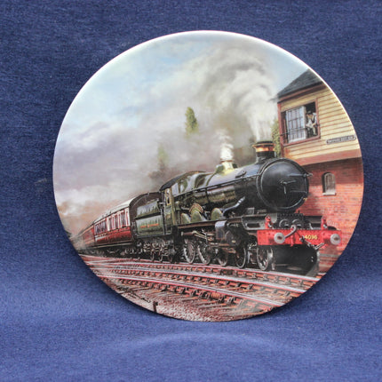 Decorative plate with a vintage steam train design on a blue fabric background
