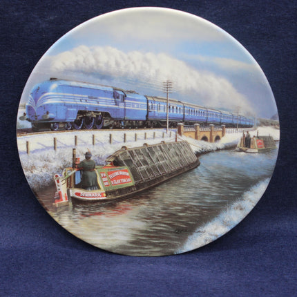 Decorative plate with a train and canal scene on a blue background