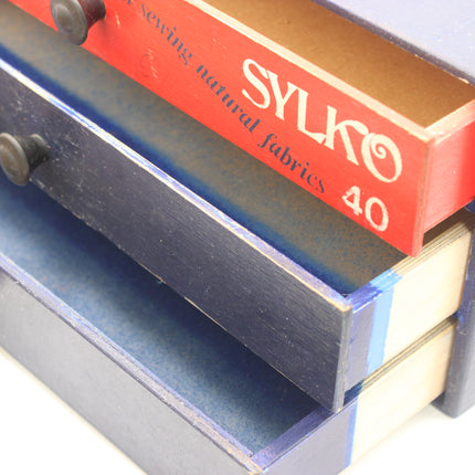 Empty Dewhurst’s Sylko thread cabinet with three drawers pulled open.