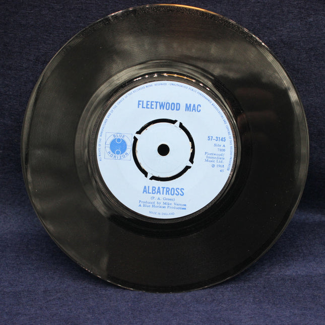 Black vinyl record with 'Fleetwood Mac' label on a dark blue background