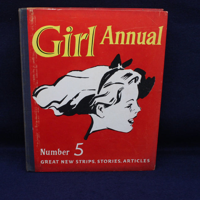 Red book titled 'Girl Annual Number 5' with a black and white illustration of a girl on a dark blue background