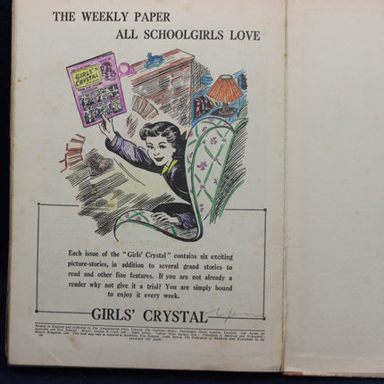 Advertisement for 'Girls' Crystal', a weekly paper for schoolgirls, with a colorful illustration of a girl holding a magazine.
