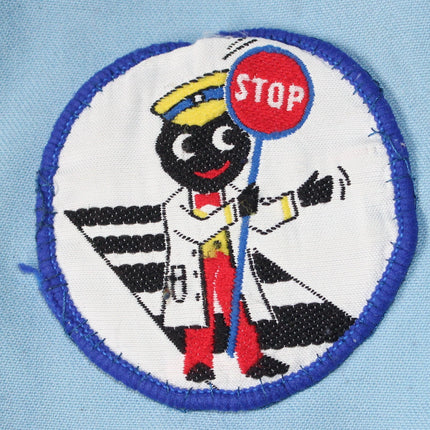 Embroidered patch of a Golly character holding a stop sign on a light blue background