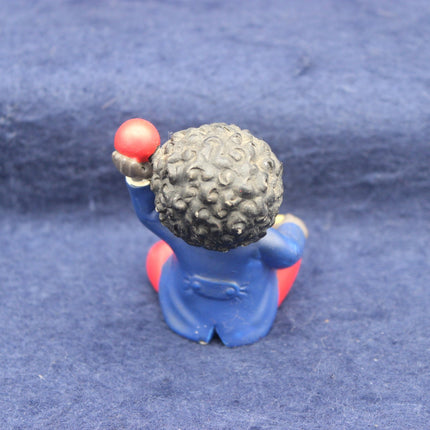 Small Golly figurine with a textured head on a blue background