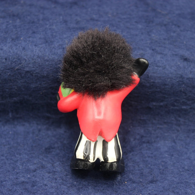 Toy figure of a Golly with a red uniform and black hat on a blue background