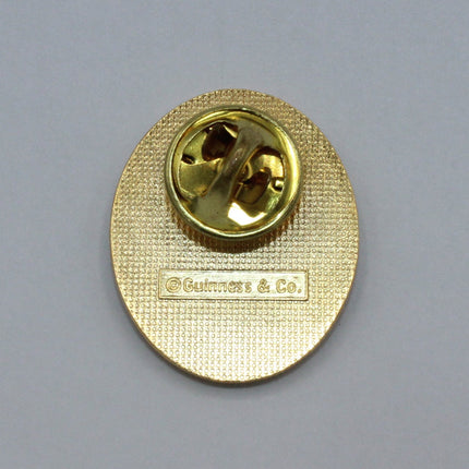 Rear of a Vintage Guinness badge on grey background